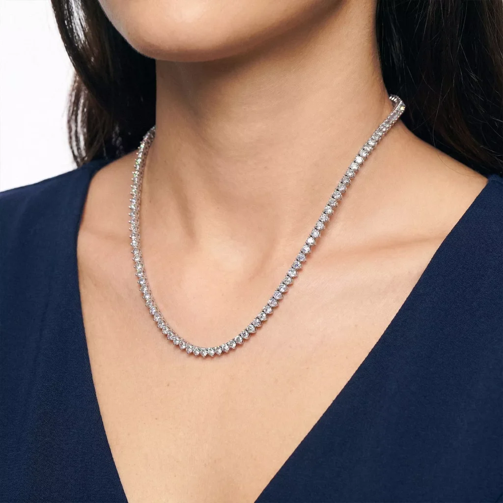 close-up of a woman's neckline shown, focusing on the tennis necklace on her neck from one of the best places to buy lab diamond tennis necklaces
